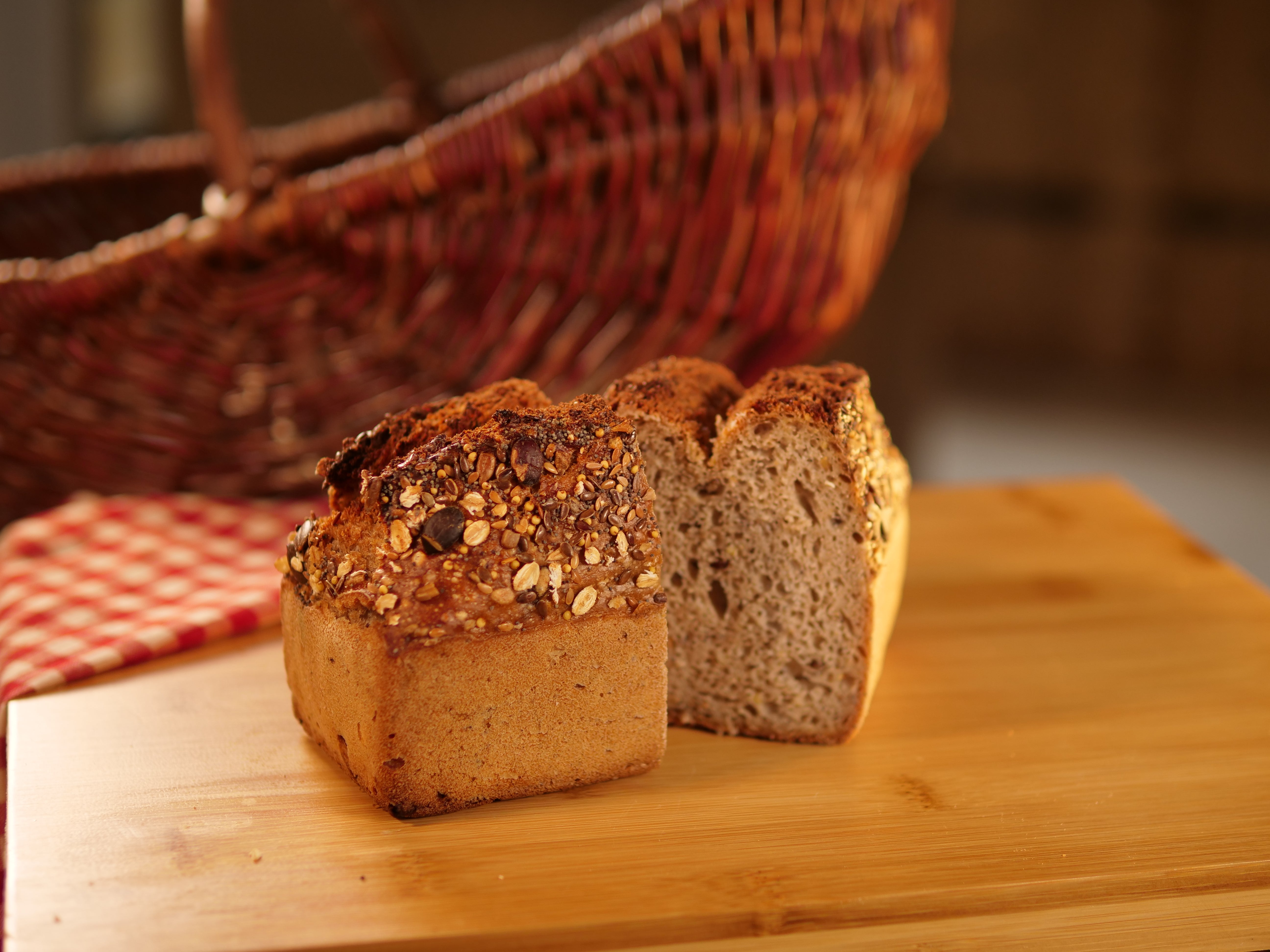 Pain nordique dense et foncé, garni de graines, posé sur une planche en bois, illustrant un pain rustique et nutritif.