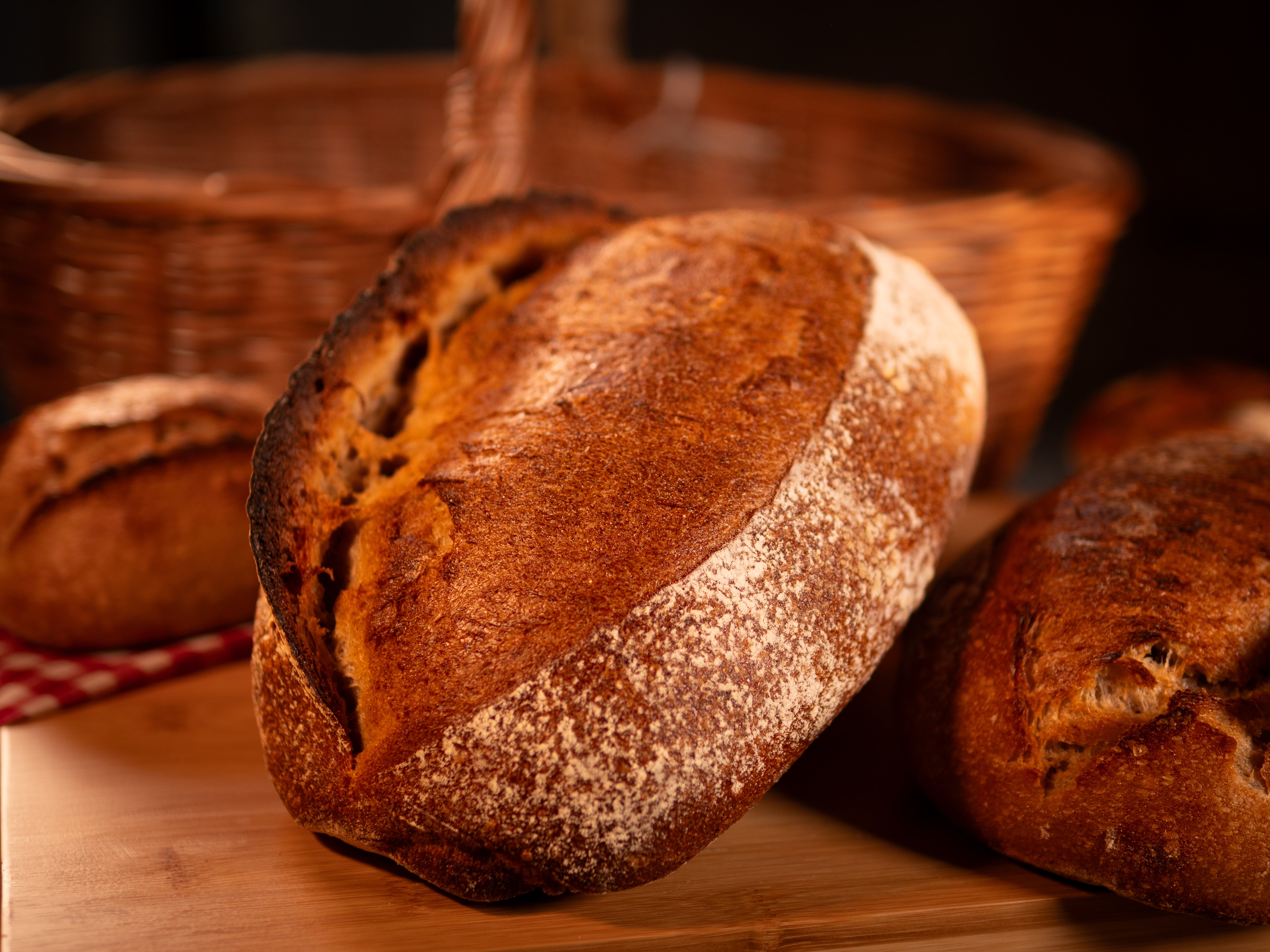 Pain de campagne à la croûte dorée et craquante, posé sur un torchon rustique, symbole d’une fabrication artisanale et traditionnelle.