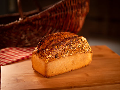 Pain nordique dense et foncé, garni de graines, posé sur une planche en bois, illustrant un pain rustique et nutritif.